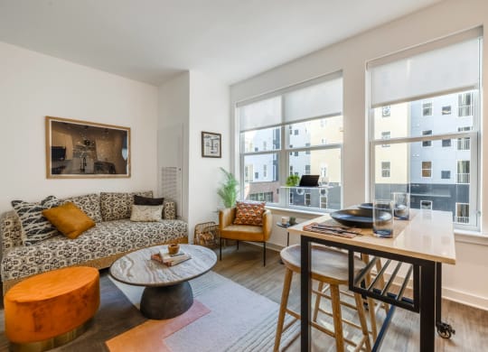 Model living room with a couch and a table and a large window