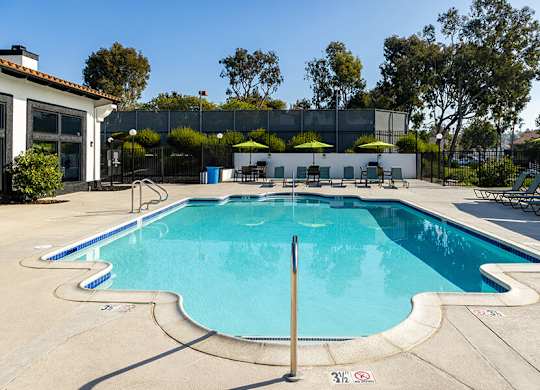 A large outdoor swimming pool with a diving board.
