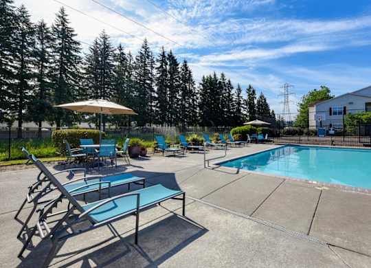 Community Swimming Pool with Pool Furniture at Landings at Morrison Apartments located in Gresham, OR.