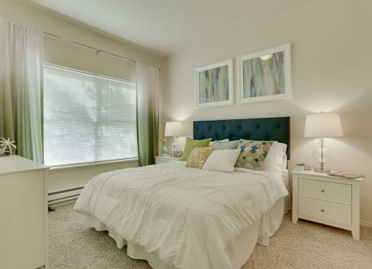 Model Bedroom with Carpet and Window View at Landings at Morrison Apartments located in Gresham, OR.
