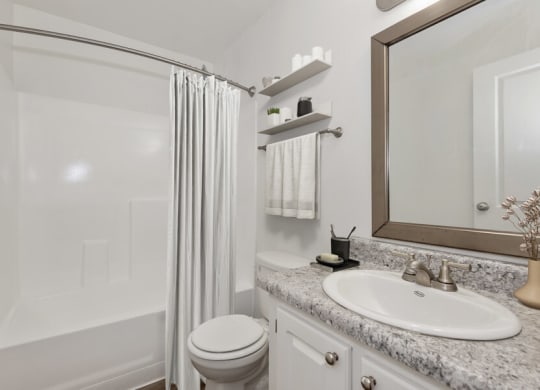 Model apartment bathroom with a shower toilet and sink and a mirror at Saratoga Ridge, Phoenix, AZ