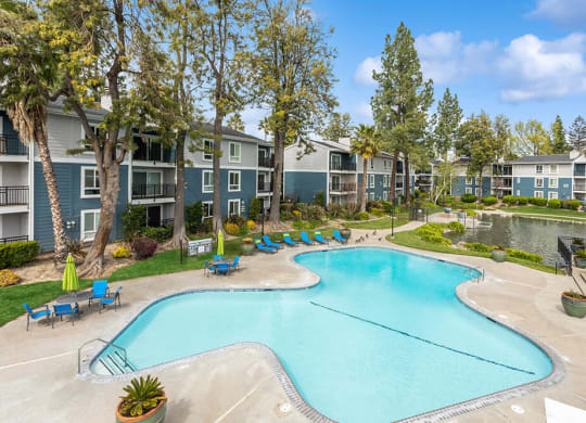 Community Swimming Pool with Pool Furniture at Fountains at Point West Apartments in Sacramento, CA.