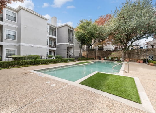 Community Swimming Pool with Pool Furniture at Bridges at Oakbend Apartments in Lewisville, TX.