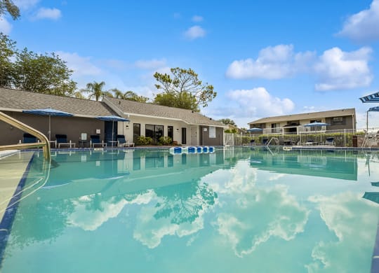 Sparkling swimming pool with clubhouse in background