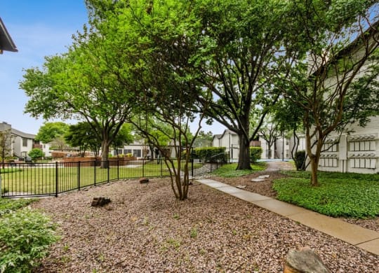 Apartment courtyard with trees and a fence