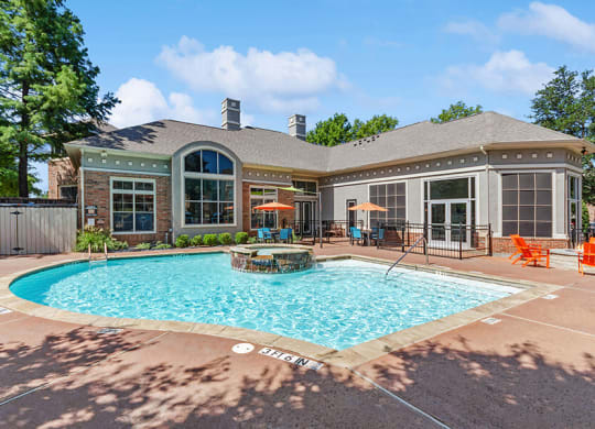 Community Swimming Pool with Pool Furniture at Belmont at Duck Creek Apartments in Garland, TX.
