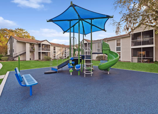 Community Playground with Slide and Blue Canopy at Vue at Baymeadows Apartments in Jacksonville, FL.