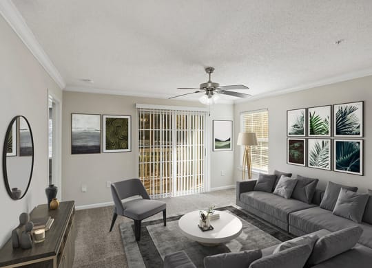 Model Living Room with Carpet and Patio Accessibility at Shadow Ridge Apartments in Riverdale, GA.