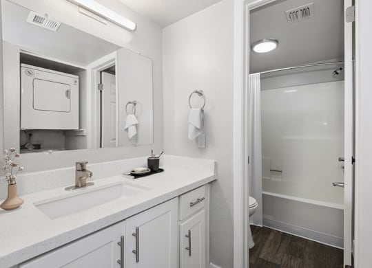 Model Bathroom with White Cabinets, Wood-Style Flooring & Shower/Tub at Crystal Creek Apartments in Phoenix, AZ.
