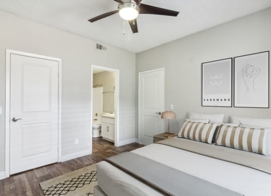 a bedroom with a bed and a ceiling fan