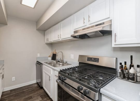 Model Kitchen with White Cabinets and Wood-Style Flooring at Indigo Park Apartments in Albuquerque, NM.