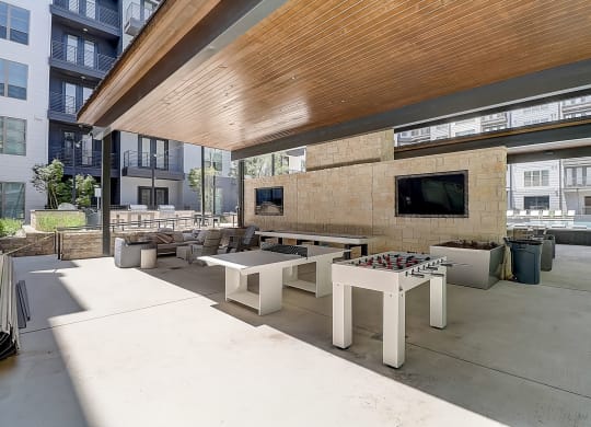 a patio with tables and chairs and a flat screen tv