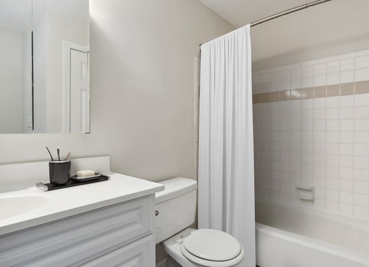 Model Bathroom with White Cabinets and Wood-Style Flooring at The Commons at Haynes Farm Apartments in Boston, MA.