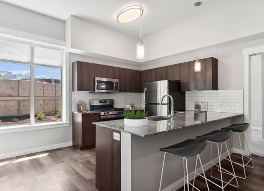 Model Kitchen with Wood-Style Flooring & Dark Oak Cabinets at Seven Skies Apartments located in Sandy, UT.