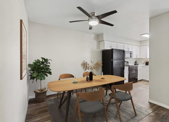 Model Dining Room with Wood-Style Flooring & View of Kitchen at Verraso Apartments in Las Vegas, NV.