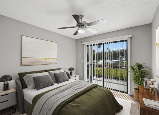 Model Bedroom with Carpet and Patio Accessibility at Fountains Lee Vista Apartments in Orlando, FL.