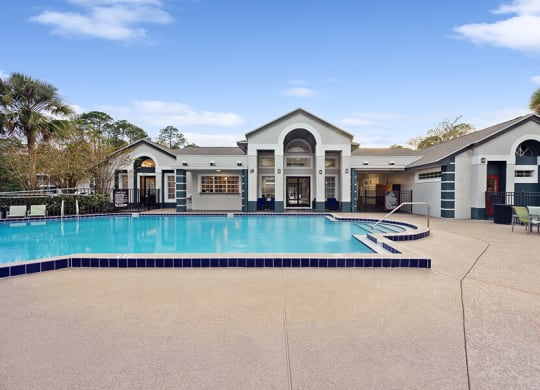 Community Swimming Pool with Pool Furniture at Vue at Baymeadows Apartments in Jacksonville, FL.