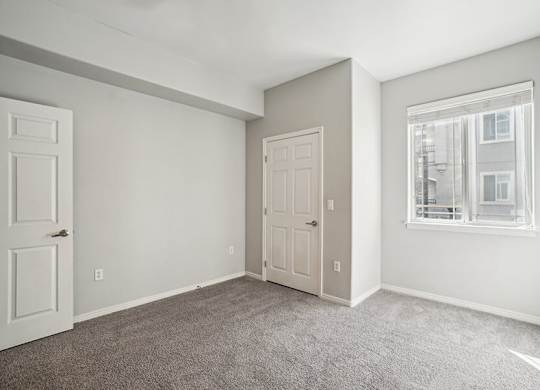 Model Bedroom with Carpet and Window View at Altitude on Fifth Apartments located in Salt Lake City, UT.