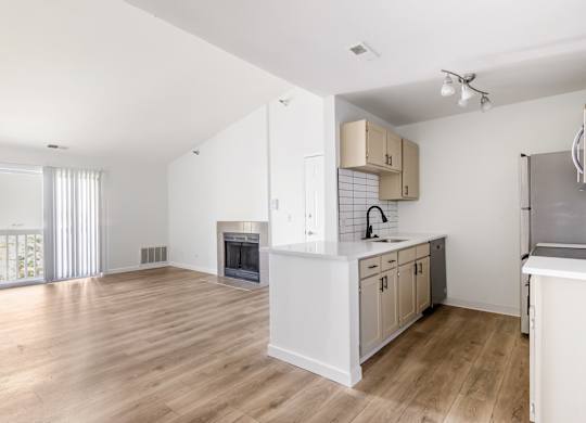 Model kitchen with a white countertop and wooden floors.