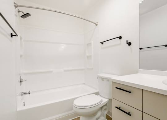 Model bathroom with a toilet, sink, and bathtub.