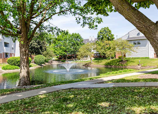 Community park with a walking path, pond and a fountain.