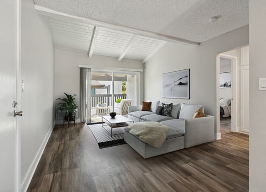 Model Living Room with Wood-Style Flooring and Patio Accessibility at Colonnade at Fletcher Hills Apartments in El Cajon, CA.