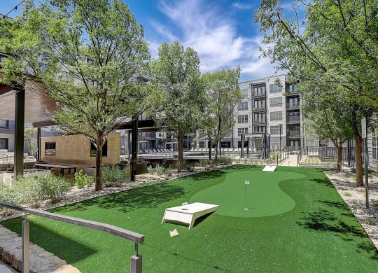 a putting green in a courtyard with a building in the background