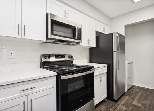 Model Kitchen with Black Appliances and White Cabinetry at Caribbean Breeze Apartments in Tampa, FL.