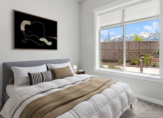Model Bedroom with Carpet and Window View at Seven Skies Apartments located in Sandy, UT.