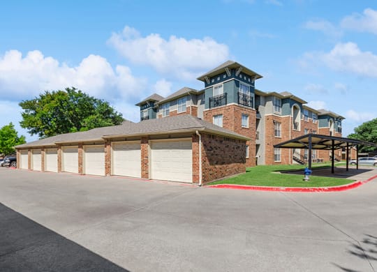 Exterior Community Building and Garages at Belmont at Duck Creek Apartments in Garland, TX.