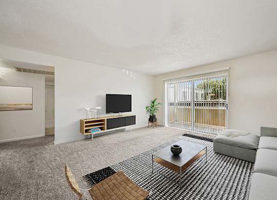 Model Classic Living Room with Carpet and Patio Accessibility at Butler Ridge Apartments located in Glendale, AZ.