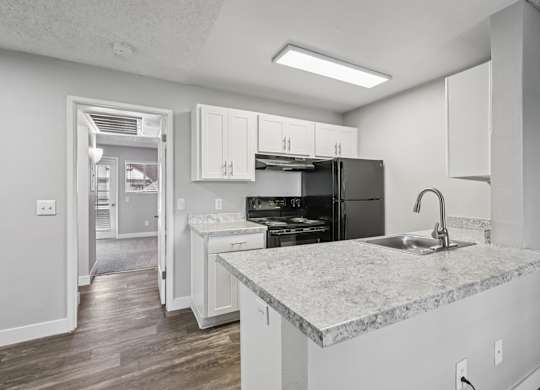 Model kitchen with a marble countertop and white cabinets.