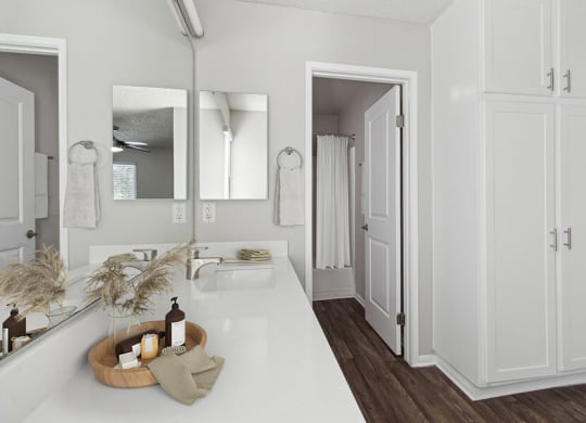 Model Bathroom with White Cabinets and Wood-Style Flooring at Colonnade at Fletcher Hills Apartments in El Cajon, CA.