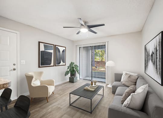 Model Living Room with Wood-Style Flooring and Patio Accessibility at Westland Park Apartments in Jacksonville, FL.