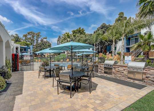 Community Picnic Tables with Umbrellas at Cove La Mesa Apartments located in La Mesa, CA.