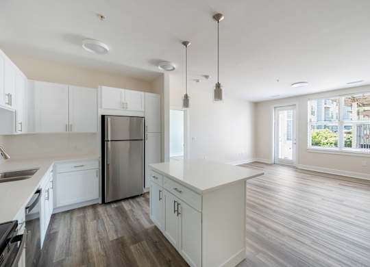 A kitchen with white cabinets and a stainless steel refrigerator.