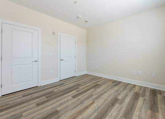 A room with two doors and a wooden floor.