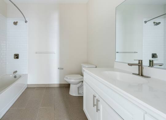 A white bathroom with a toilet, sink, and bathtub.