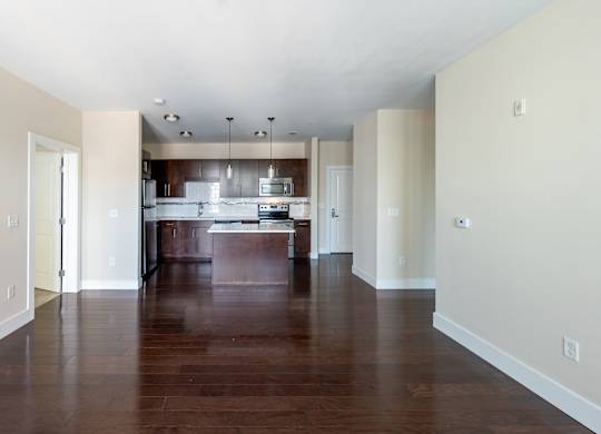 A kitchen with a wooden floor and white walls.