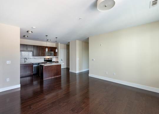 A kitchen with a wooden floor and white walls.