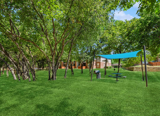 Outdoor BBQ Area with Canopy at Belmont at Duck Creek Apartments in Garland, TX.