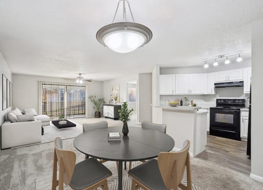 Model Dining Room with Carpet and View of Kitchen and Living Room at Westland Park Apartments in Jacksonville, FL.