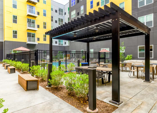 a patio with tables and chairs and a pergola