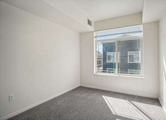 Model Bedroom with Carpet and Window View at Altitude on Fifth Apartments located in Salt Lake City, UT.
