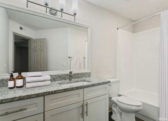 Model bathroom with a sink, toilet, and bathtub at Retreat at Crosstown Apartments