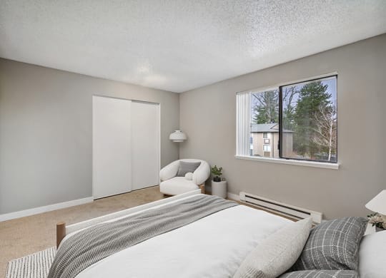 Model Bedroom with Carpet and Window View at Grammercy Apartments located in Renton, WA.