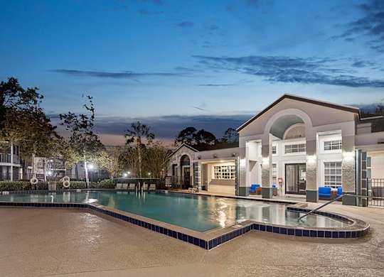 Community Swimming Pool with Pool Furniture at Vue at Baymeadows Apartments in Jacksonville, FL.