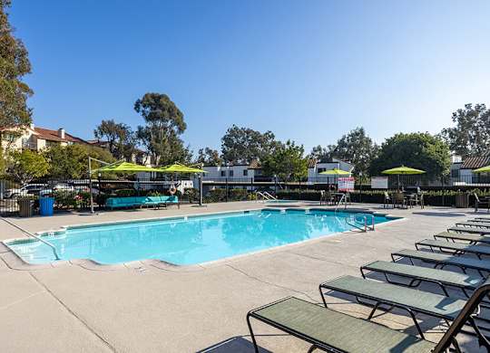 Community Swimming Pool with Pool Furniture at Santa Fe Ranch Apartments located in Carlsbad, CA.