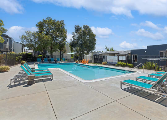 Community Swimming Pool with Pool Furniture at Colonnade at Fletcher Hills Apartments in El Cajon, CA.