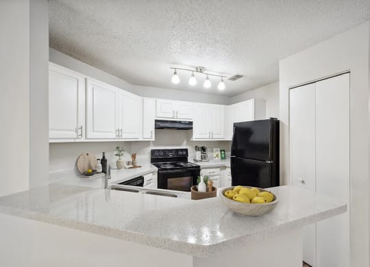 Model Kitchen with White Cabinets and Wood-Style Flooring at Westland Park Apartments in Jacksonville, FL.